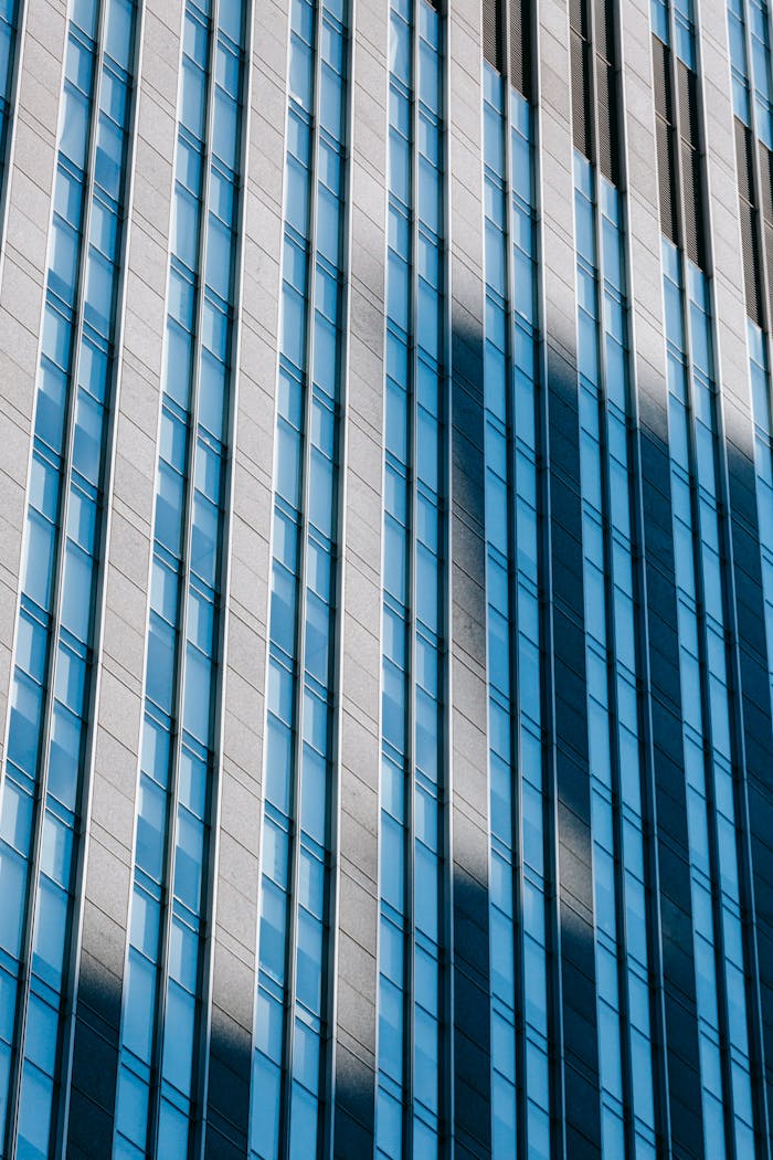 Close-up of a skyscraper's modern facade in daylight with dramatic shadows.